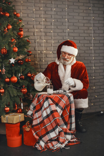 圣诞老人圣诞老人在圣诞树旁休息家居装饰给圣诞老人的礼物圣诞树牛奶微笑