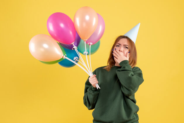 聚会正面图是一位年轻的女士 手里拿着五颜六色的气球飞机年轻庆祝