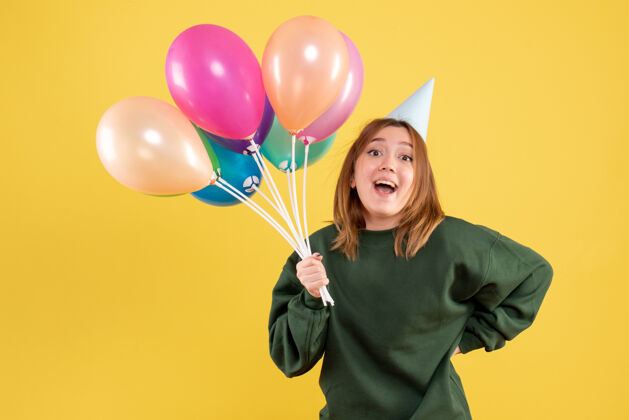 女人正面图是一位年轻的女士 手里拿着五颜六色的气球庆祝颜色年轻