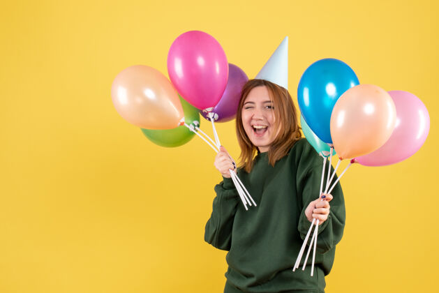 庆祝正面图：带着彩色气球的年轻女性乐趣年轻的女性一年