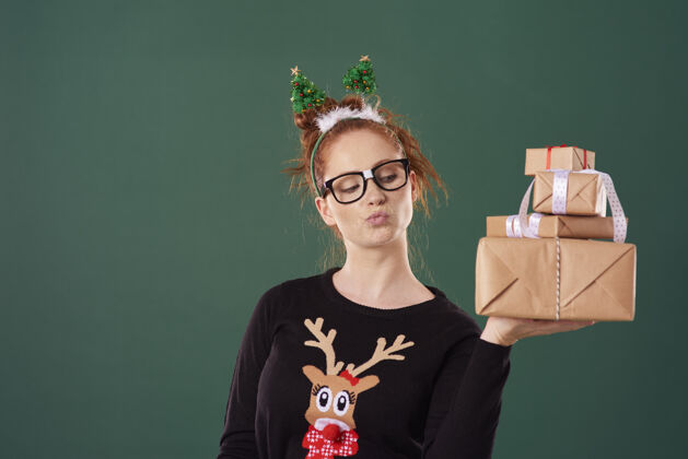 庆祝拿着一堆圣诞礼物的女人努力肖像幽默
