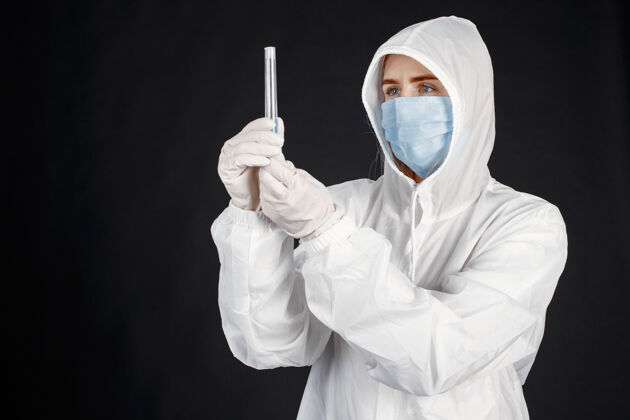 妇女戴着医用面罩的医生冠状病毒隔离在黑墙上穿着防护服的女人肖像职业护士