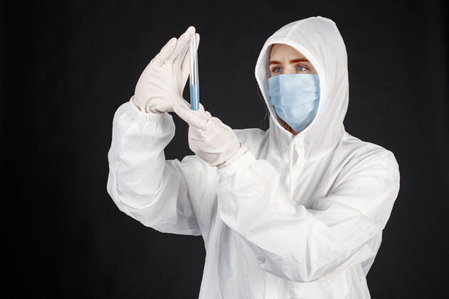 妇女戴着医用面罩的医生冠状病毒隔离在黑墙上穿着防护服的女人医学肖像医学