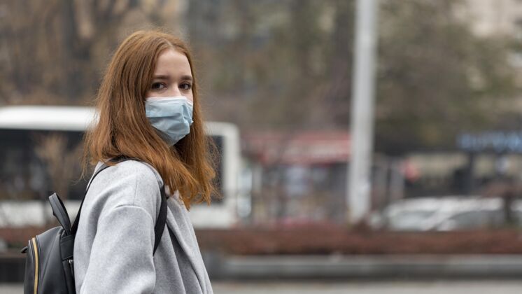 大流行城市里戴着医用口罩的女人的侧视图水平病毒安全