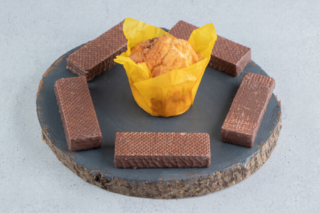 威化饼干巧克力薄饼围绕在大理石背景板上的纸杯蛋糕上美味美味糕点