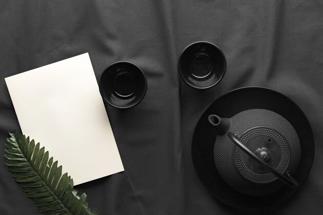 陶瓷带茶壶和叶子的深色碗的俯视图餐具茶壶家居用品