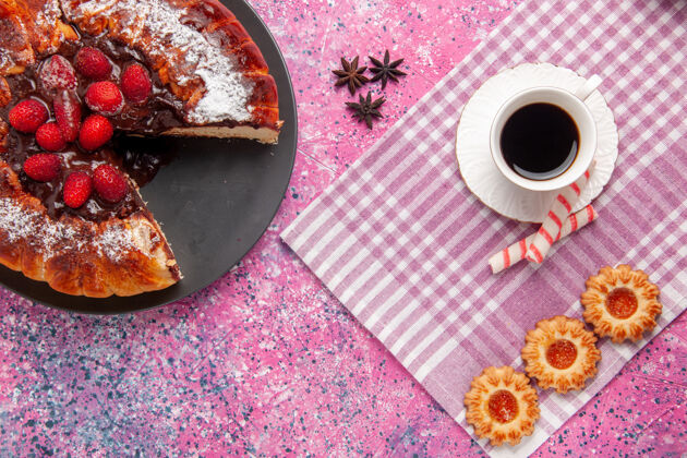视图俯瞰美味的巧克力蛋糕配上饼干和一杯茶放在粉红色的桌子上饼干甜甜的甜点蛋糕烤馅饼杯子顶部磁盘