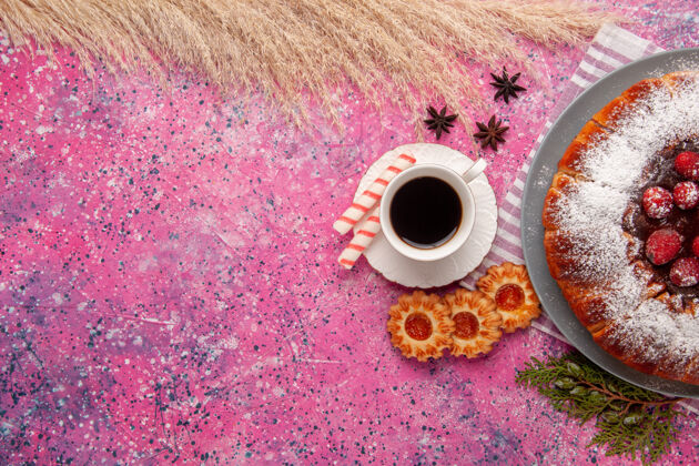 视图俯瞰美味的草莓蛋糕糖粉配上一杯茶和饼干 背景为浅粉色蛋糕甜饼干饼干茶颜色磁盘咖啡