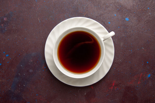 热的顶视图茶杯内盘和茶杯上底色为深色茶饮彩色照片甜美背景视图马克杯