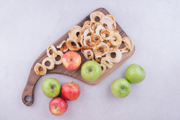 东方干苹果片和新鲜苹果放在灰色木板上产品热带清淡
