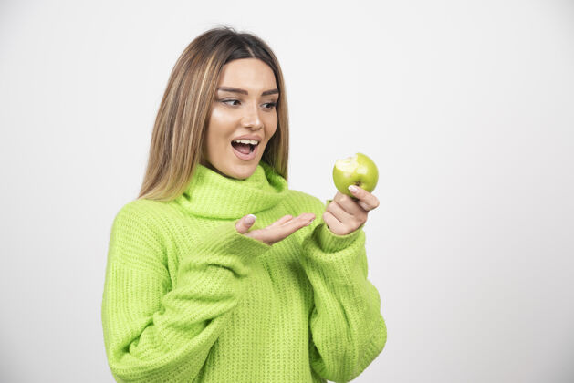 健康穿着绿色t恤的年轻女子手里拿着一个苹果苹果美丽成人