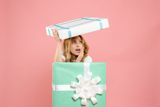 持有正面图年轻女性藏在礼物盒里成人礼物圣诞节