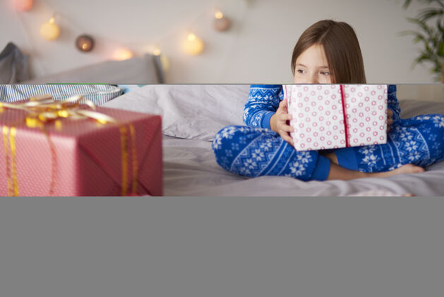 孩子带着圣诞礼物的快乐小女孩盒子深情睡衣
