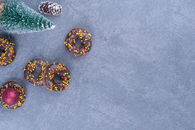 食物美味的甜甜圈配圣诞树和松果吃甜圣诞节