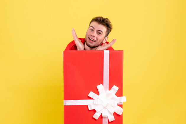 礼物正面图年轻男子藏在礼品盒内纸里面年轻