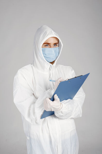 医学戴着医用面罩的医生冠状病毒主题隔离在白墙上穿着防护服的女人工作文件夹西装