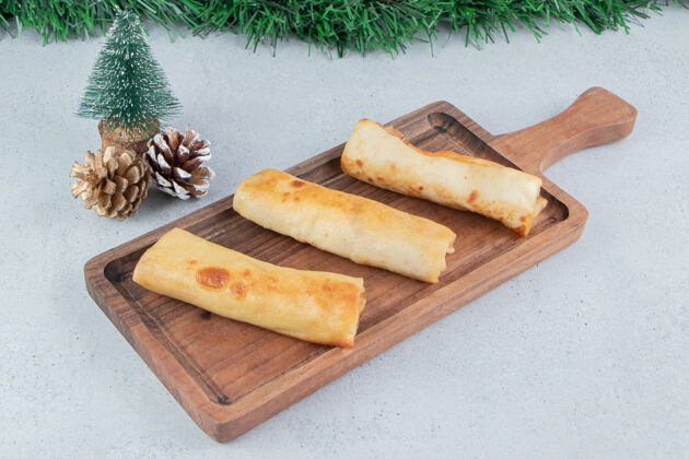 包装圣诞装饰品和一盘薄饼放在大理石背景上早餐美味商品