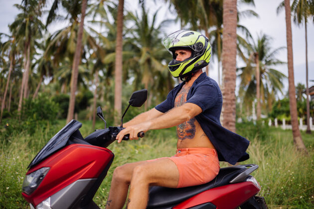 夏天在热带丛林的田野上纹着红色摩托车的壮汉生活旅游自由