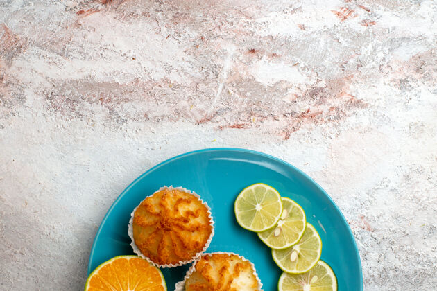 糕点俯瞰美味的蛋糕与柠檬片内板上的白色背景水果柑橘蛋糕烤面团饼干糖背景蛋糕饼干