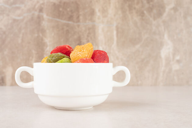质量彩色杏子和樱桃在一个陶瓷杯子里素食食物产品