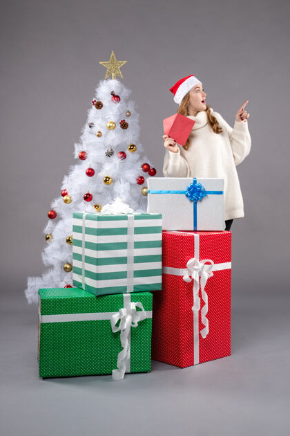 圣诞帽拿着信封的年轻女人圣诞树圣诞树女
