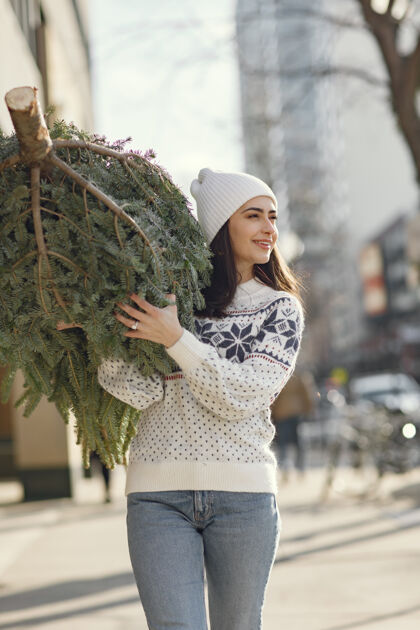 成人优雅的女孩买了一棵圣诞树自然木材帽子