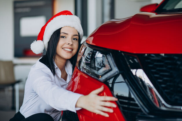 可爱圣诞节汽车展厅里的女人驾驶运输新