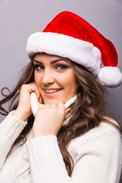 肖像戴着圣诞红帽子的女商人微笑着的圣诞女孩的独立画像圣诞老人钱帽子