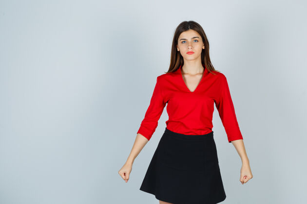 人穿着红色上衣 黑色短裙的年轻女子握紧拳头 看上去很自信工作年轻裙子