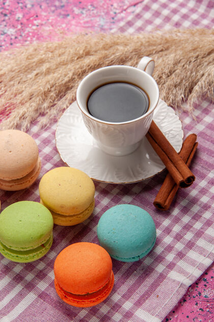马卡龙一杯加肉桂和法式马卡龙的茶 放在粉红色的桌上蛋糕 饼干 甜甜的糖鸡蛋生的风景