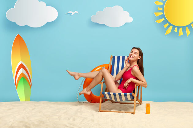 海洋苗条好看的女性在沙滩躺椅上休息 露出修长的双腿 穿着红色比基尼 有着欢快的神情情绪高兴健身
