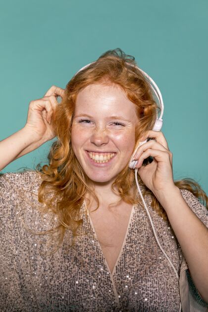 女人微笑的女人用耳机听音乐生日聚会聚会女人