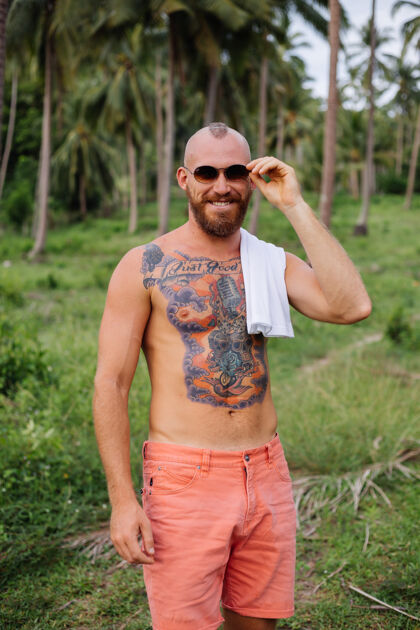 公园丛林热带野地上纹身的壮汉不穿衬衫旅游时尚时髦