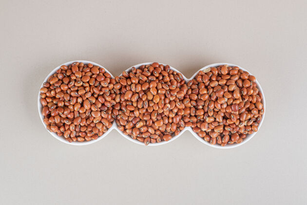 甜味棕色的豆子放在水泥上的陶瓷板上生的美味植物