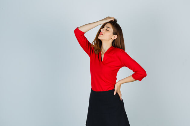 衬衫一个年轻的女人 手放在头上 手放在臀部 穿着红色上衣欢快积极成功