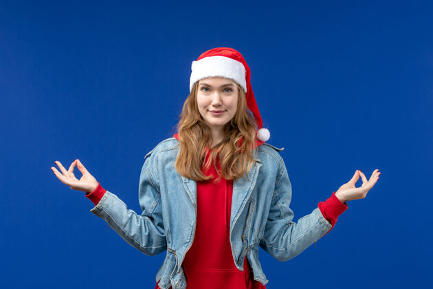 微笑前视图年轻女性沉思在一个蓝色的背景情感圣诞假期的颜色冥想观点年轻