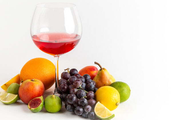 玻璃正面视图红色酒杯内有不同的新鲜水果 白色墙上有酒精饮料 威士忌酒吧水果饮料新鲜