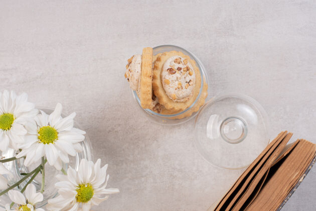 零食燕麦葡萄干曲奇在玻璃罐 书和雏菊饼干坚果罐子