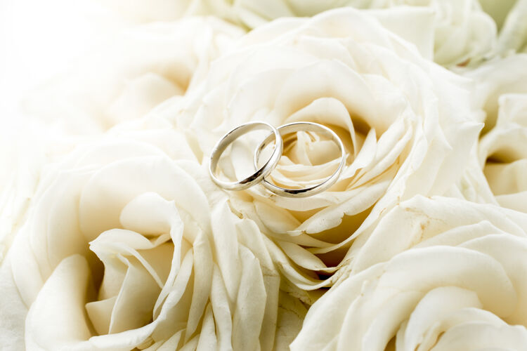 新娘两个结婚戒指躺在婚礼花束色调宏观观点优雅手指求婚