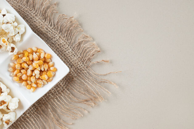 生物把爆米花和玉米种子放在一个白色的盘子里厨房用餐植物
