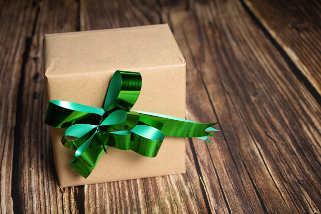 传统木制背景上有绿色丝带的礼品盒特写礼物装饰树