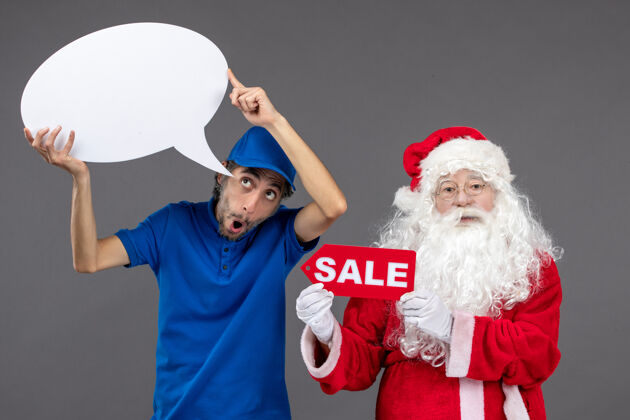 圣诞圣诞老人与男信使持有白色标志和灰色墙上的销售横幅前视图快乐前面举行