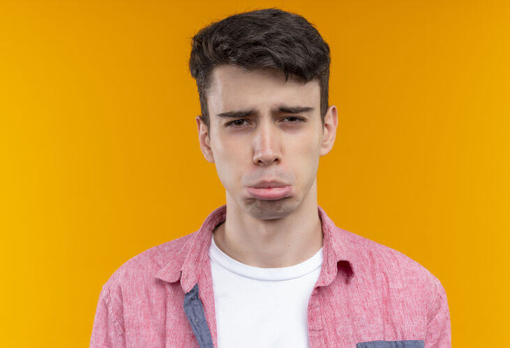 衬衫悲伤的白人年轻人穿着粉红色衬衫在孤立的橙色背景年轻悲伤橙色