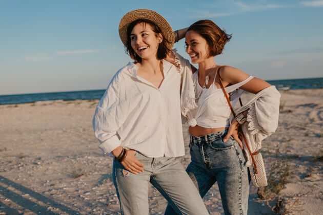 女人两个年轻女子在日落海滩上玩得很开心 男女同性恋爱情浪漫Lgbt伴侣女同性恋