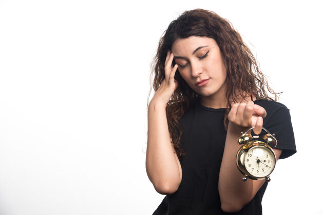 年轻戴着白色背景的时钟的女人高质量的照片卷发女性手表