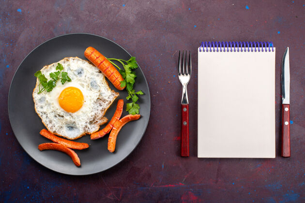食物顶视图炒鸡蛋与绿色和香肠内板上的深紫色表面盘子菜肴香肠