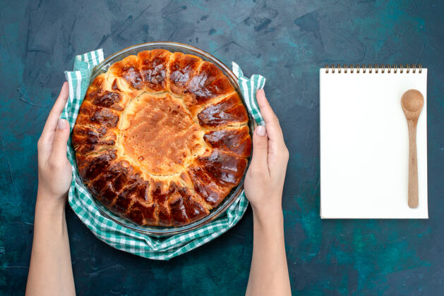 托盘俯瞰美味的烤蛋糕圆形甜甜的玻璃平底锅在浅蓝色的桌子上顶部美味烘焙