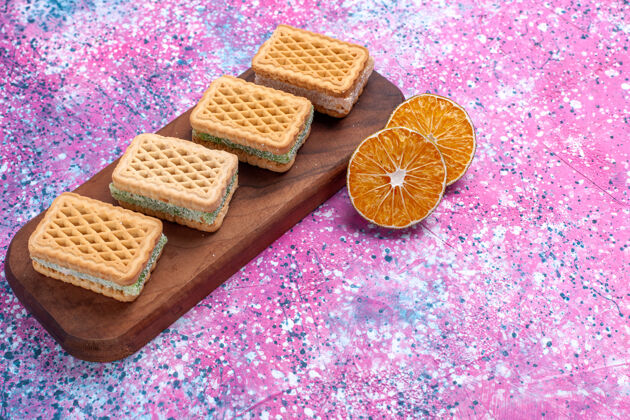 烘焙正面图：粉色背景上填充水果奶油的华夫饼干水果饼干甜点