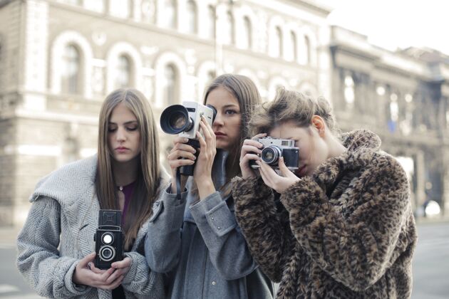学生三位女性朋友一起用相机拍照女性成年人户外
