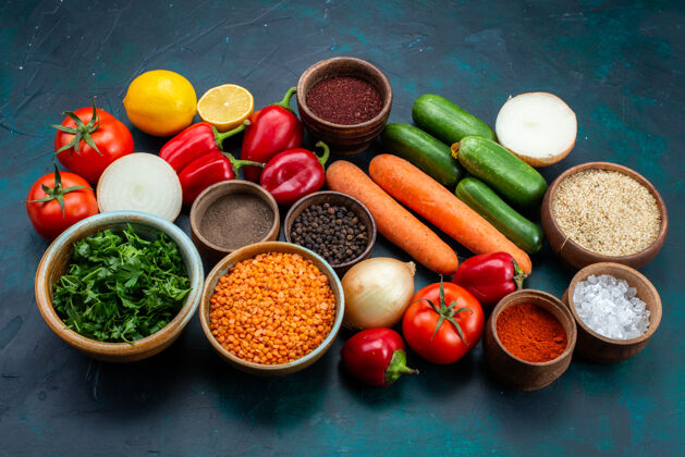 蔬菜在深蓝色的桌子上半俯视新鲜蔬菜和蔬菜及调味品调味品绿色西红柿